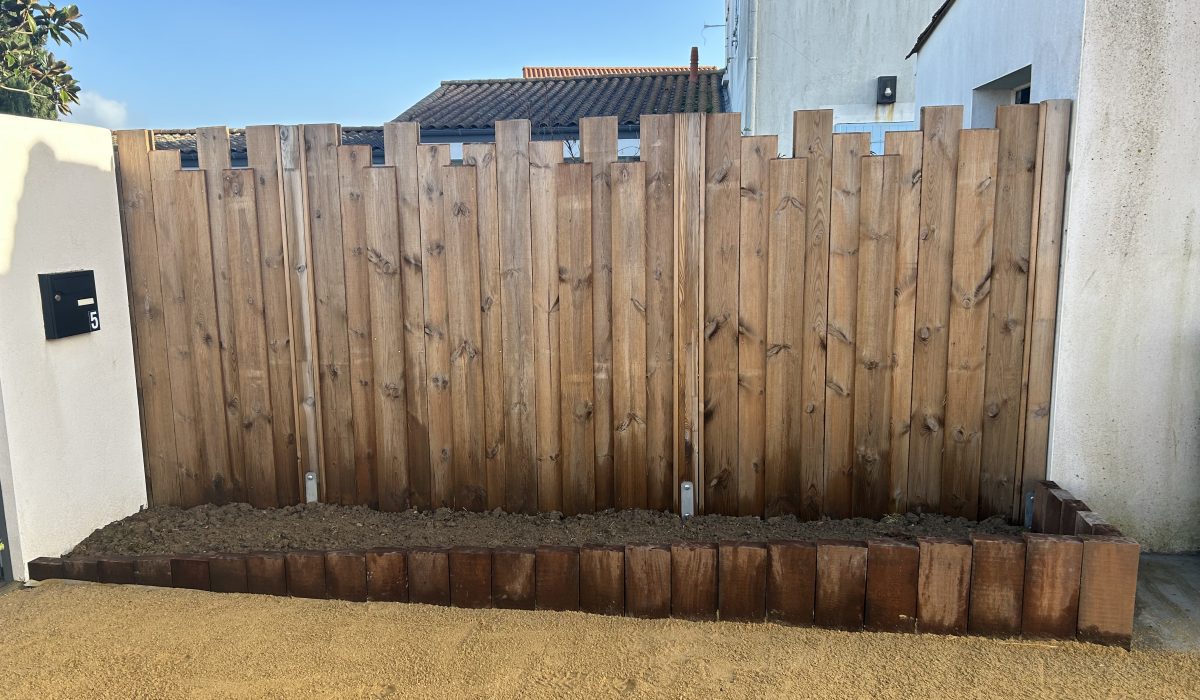 Clôture en panneaux bois et massif avec bordure en traverses paysagères